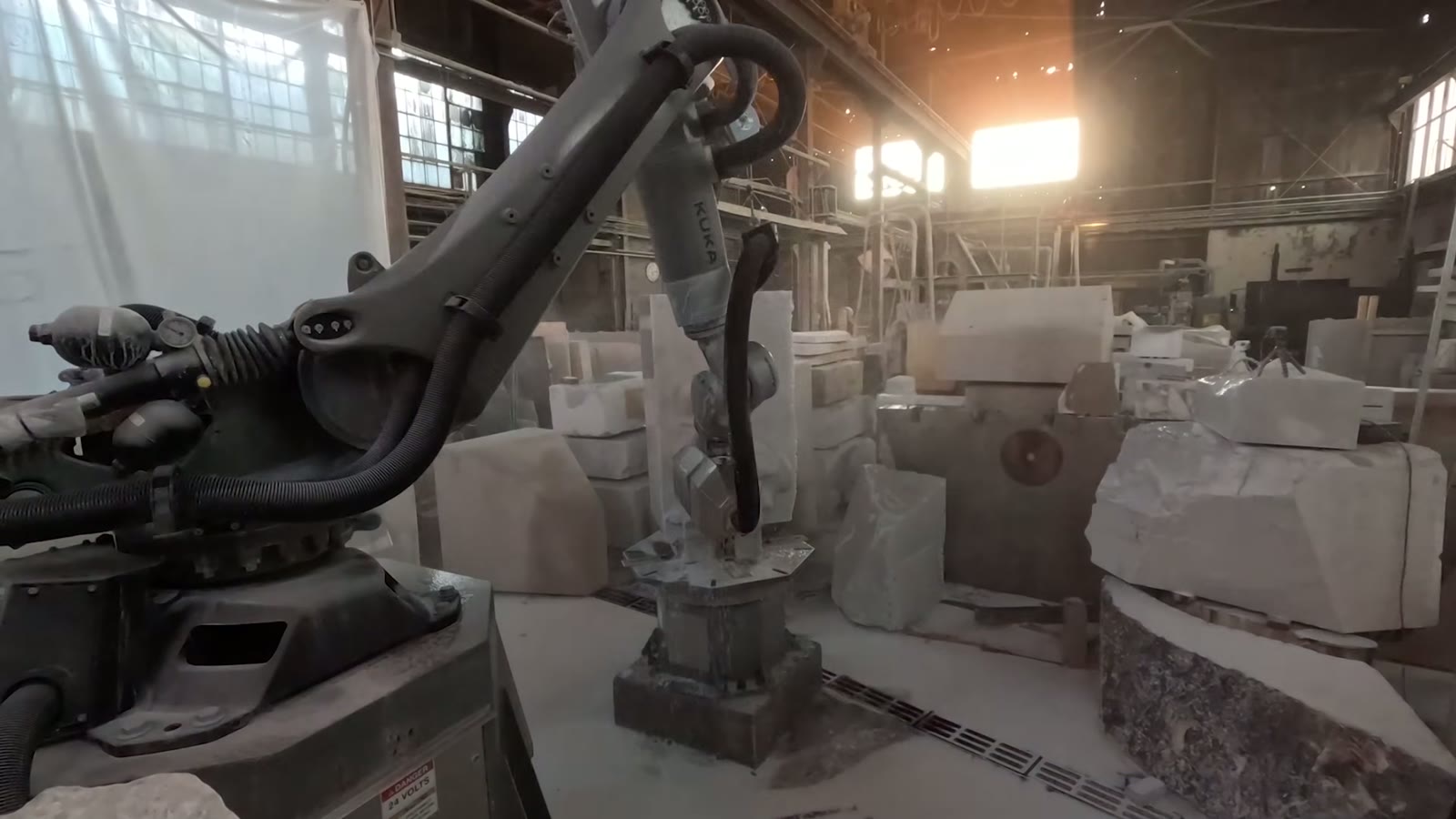 A KUKA robotic arm roughing the Grumpy form from solid marble in the stone workshop